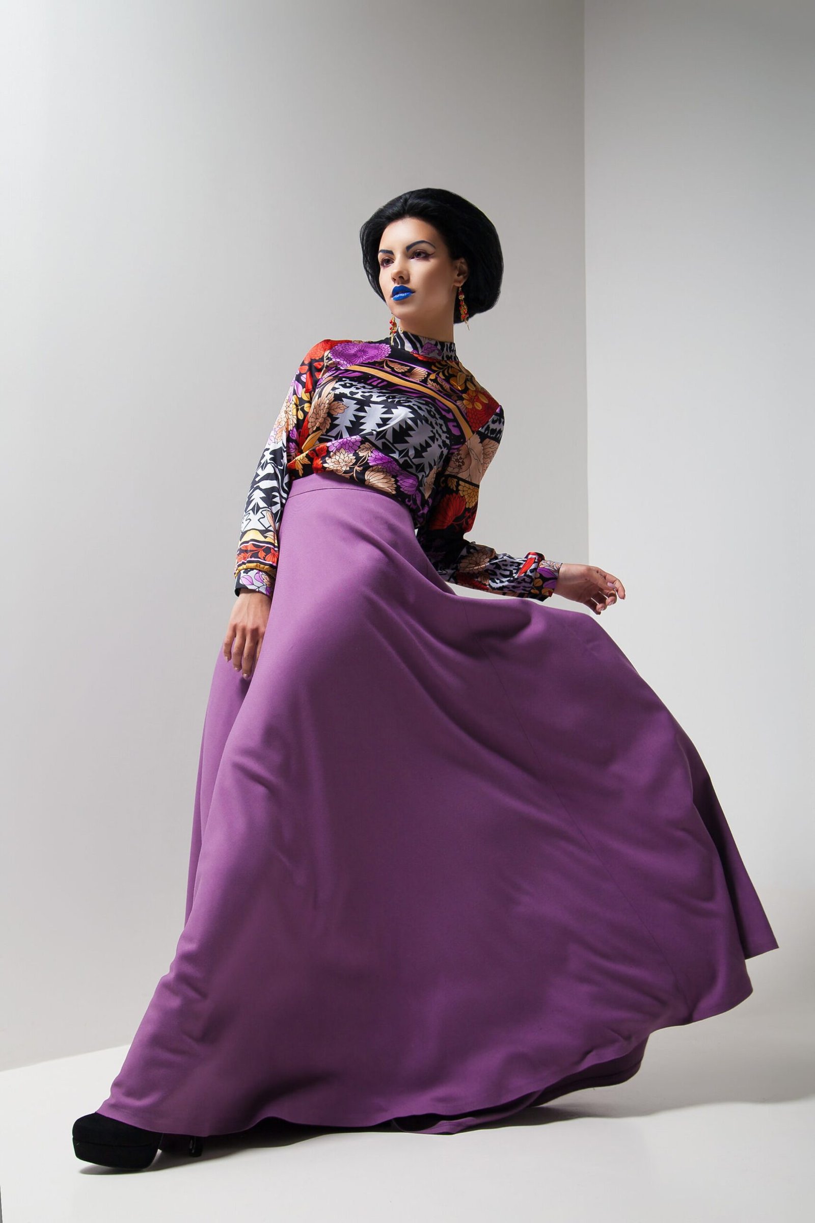 Fashion photo of young magnificent woman in purple dress. Studio photo