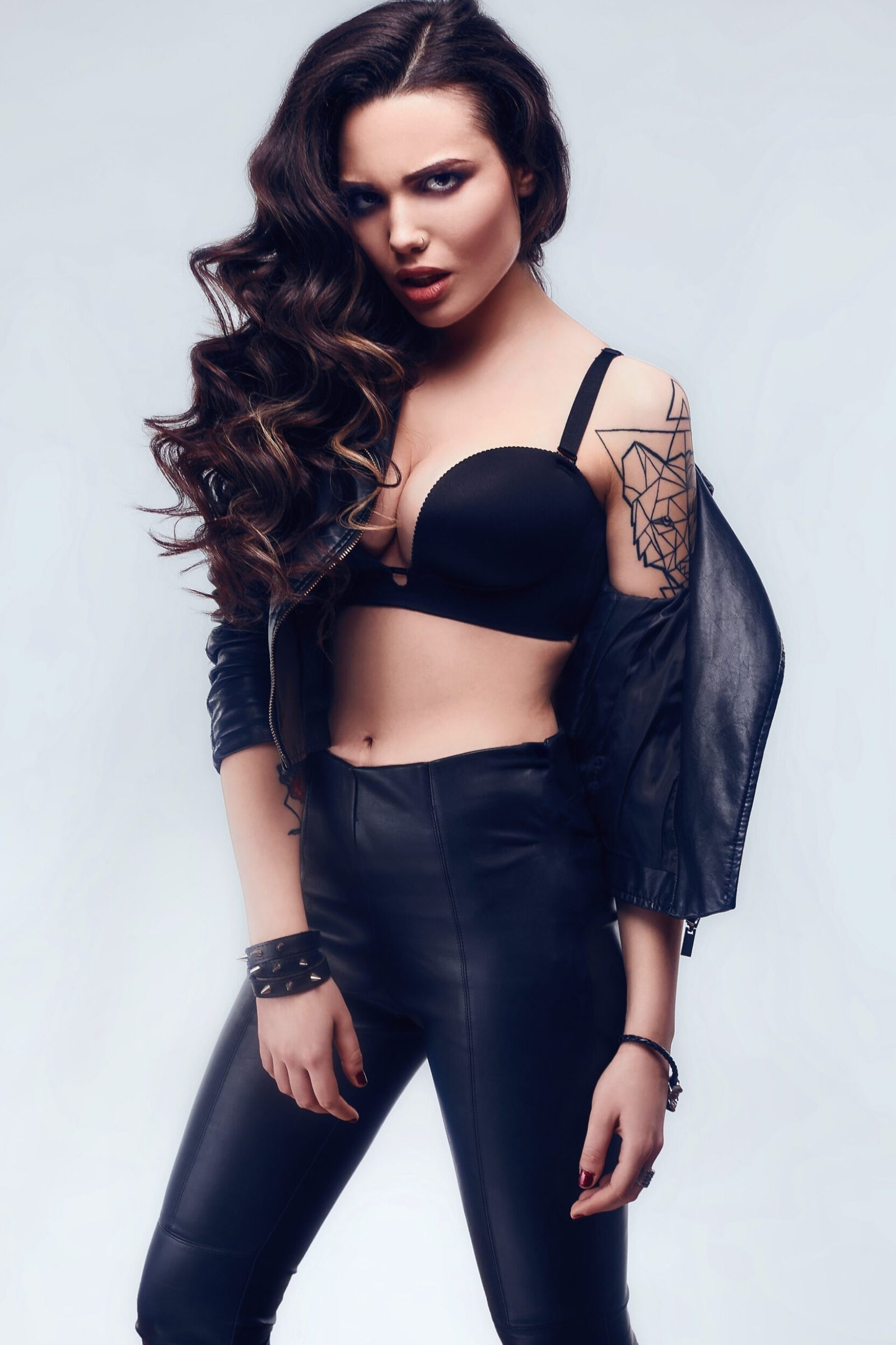 Portrait of young sexy girl with long hair in leather jacket isolated on white background in studio